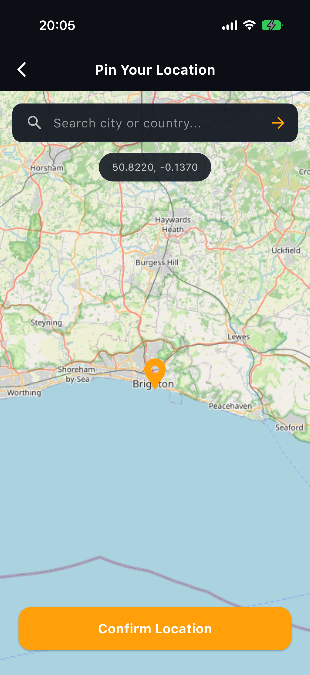 Sun Hours map location picker showing an OpenStreetMap view of Brighton and the Sussex coast with an orange pin on the town, a chip reading 50.8220, -0.1370, a search field across the top and a Confirm Location button at the bottom, shown in the app's blue daytime palette.